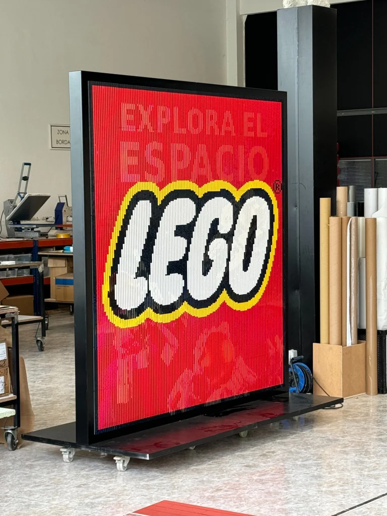 Vista lateral izquierda de mosaico lenticular construido con LEGO y que representa el logo de la marca.