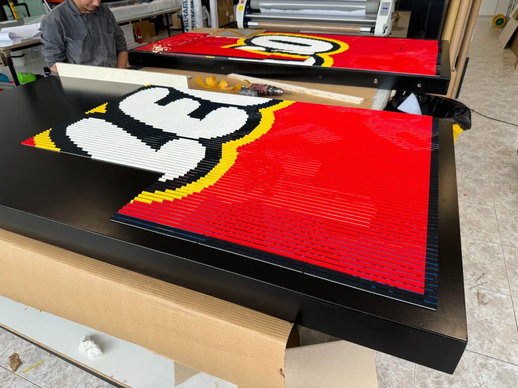 Proceso final de montaje de mosaico lenticular construido con LEGO para la campaña Explora el Espacio