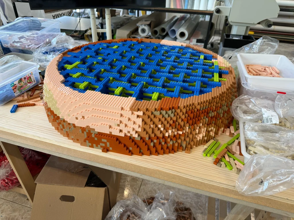 Vista lateral de proceso de montaje de reproducción de planeta Marte construida con LEGO