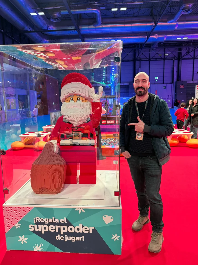 Escultura de Papá Noel construida con LEGO expuesta en una vitrina en IFEMA durante la Navidad de 2023 y su creador Pablo González
