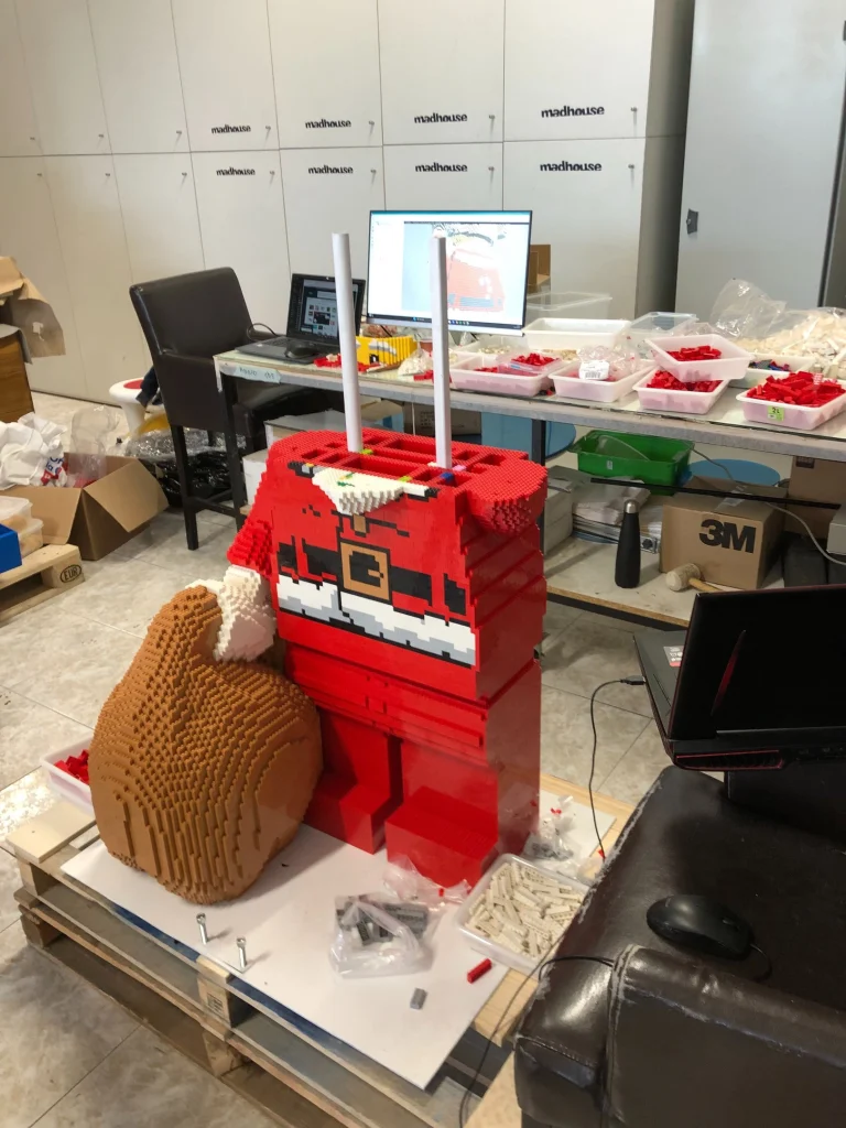 Detalle de proceso de montaje del cuerpo de escultura de Papá Noel construida con LEGO