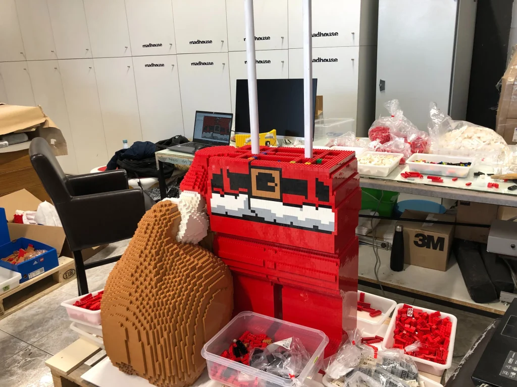 Detalle de proceso de montaje del cuerpo de escultura de Papá Noel construida con LEGO 
