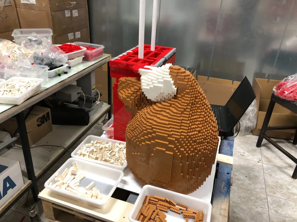 Detalle de proceso de montaje  de saco de regalos de escultura de Papá Noel construida con LEGO