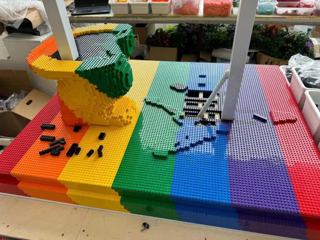 Side view of the construction process for the multicolored “Bear and Strawberry Tree” sculpture base made with LEGO