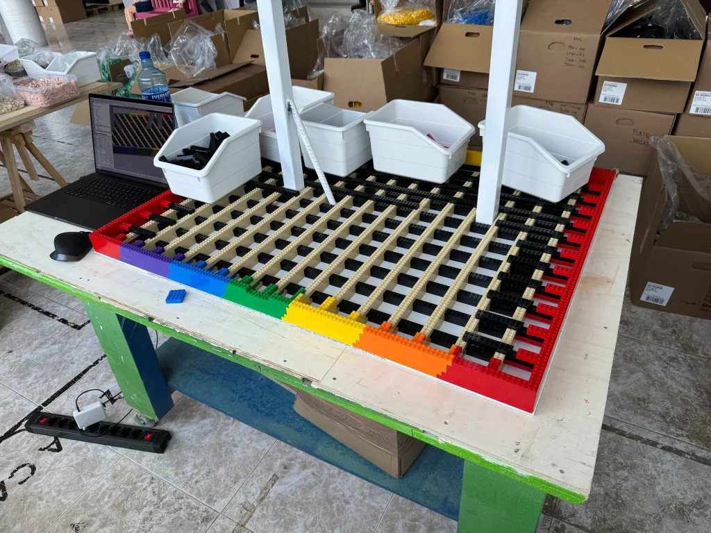 Side view of the construction process for the stand of the multicolored “Bear and Strawberry Tree” sculpture made with LEGO