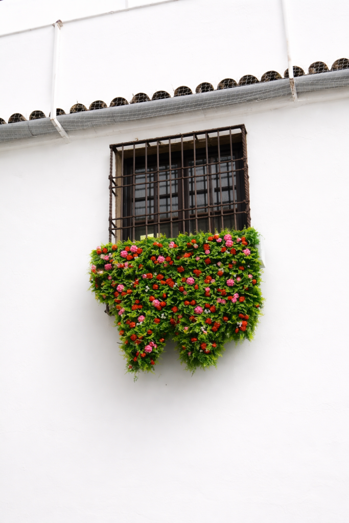 A window with a hanging garden built with LEGO for the Patios Festival in Córdoba.