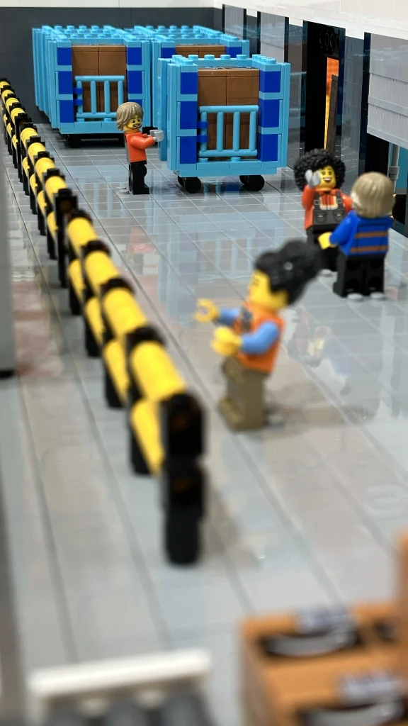 Detalle de minifiguras representando trabajadores de Amazon en Maqueta centro logístico realizada con LEGO