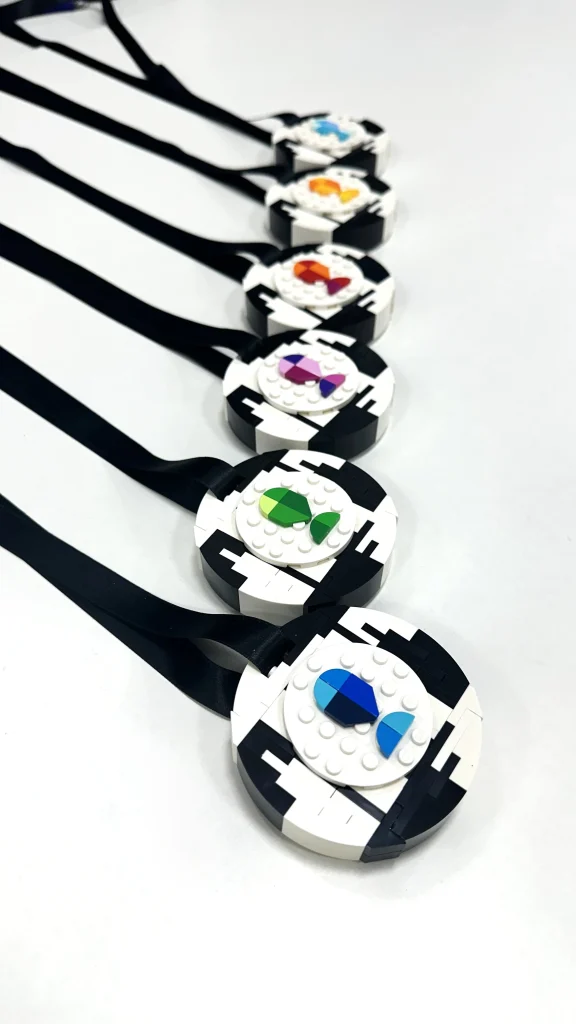 Vista posterior de medallas LEGO todas con una interpretación de un trofeo, cada una en un color